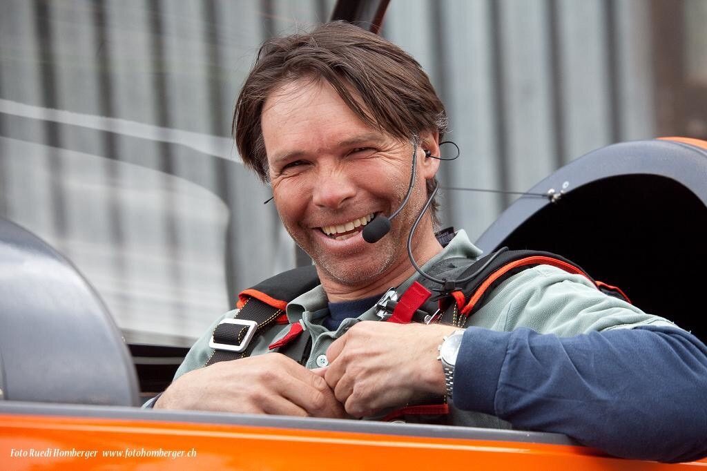Roland lacht mit Headset im Cockpit